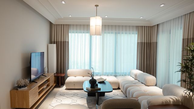 Contemporary living room with a low curved modular sofa, coffee table, and wooden media unit.